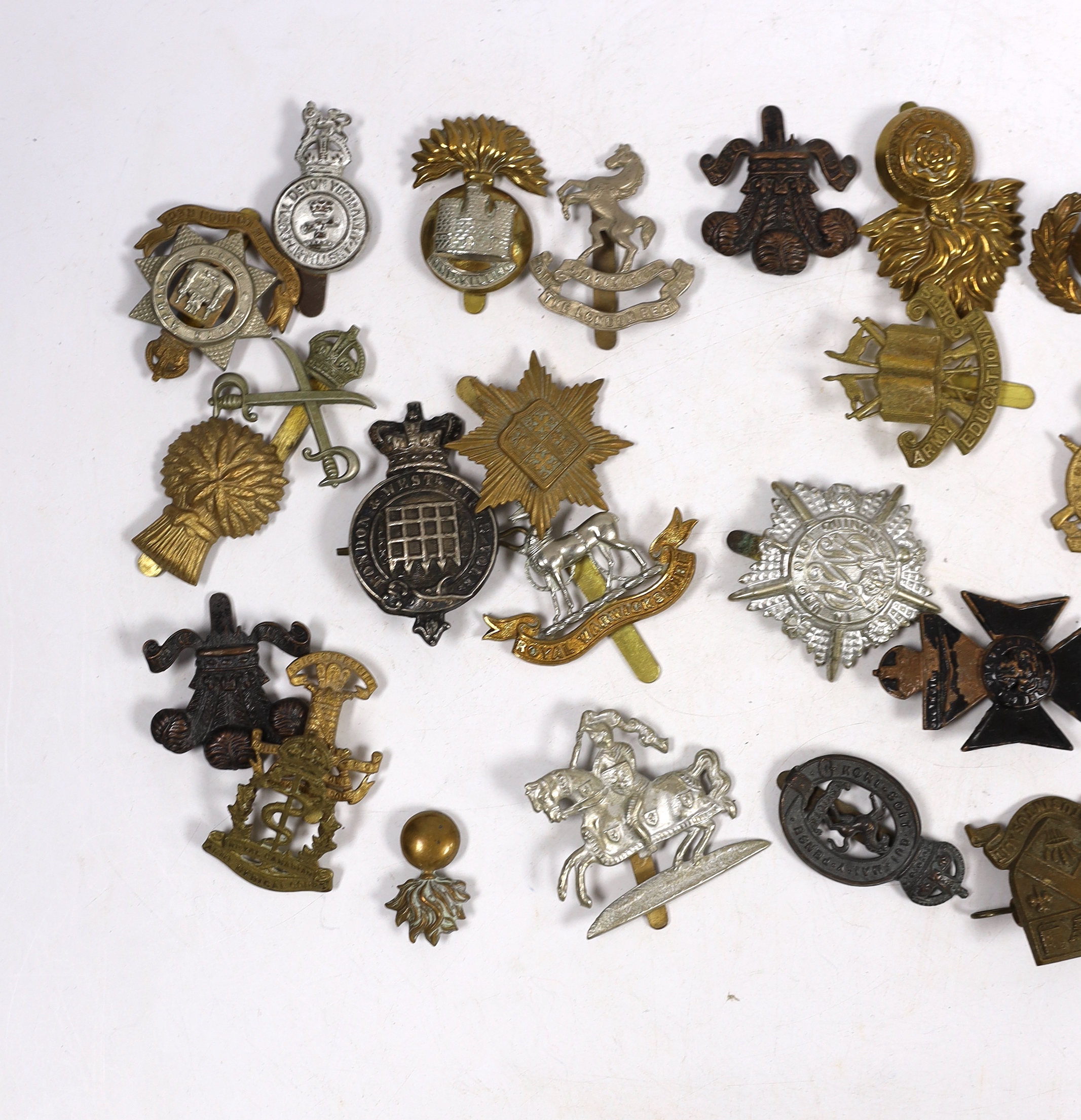 Thirty military cap badges including Royal Warwickshire, Hampshire Yeomanry Carabiniers, Inniskillin, Royal Canadian, AMC, Dorset, Army Educational Corps, London and West Rifle Volunteers, etc.